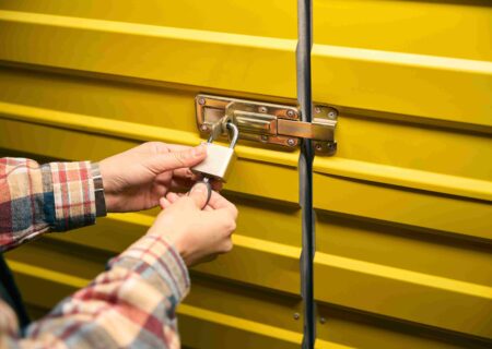 A man locks up his self storage container using a padlock.